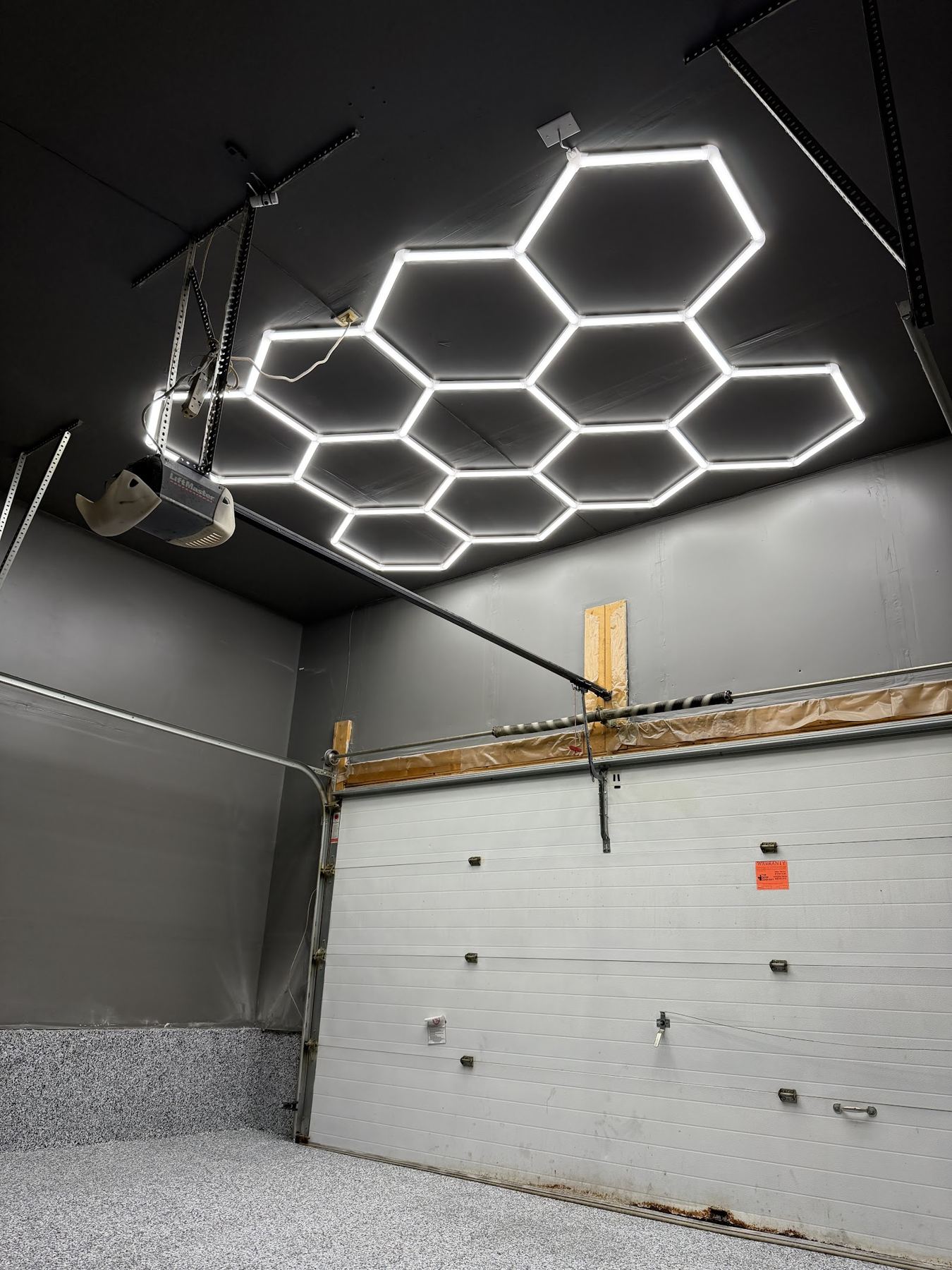 A hexagon LED light grid on a garage ceiling