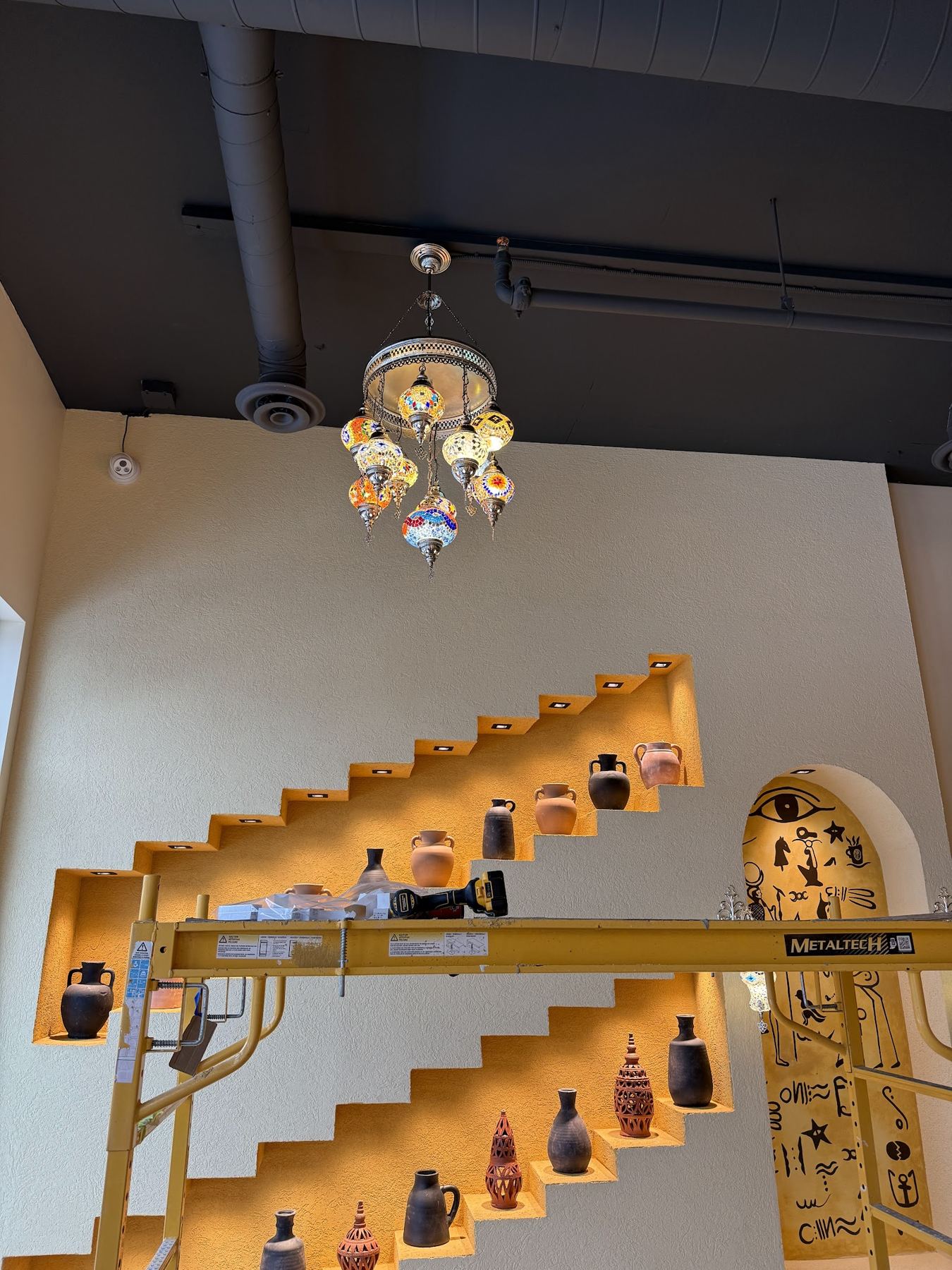 A floating staircase with lit display shelves along the wall