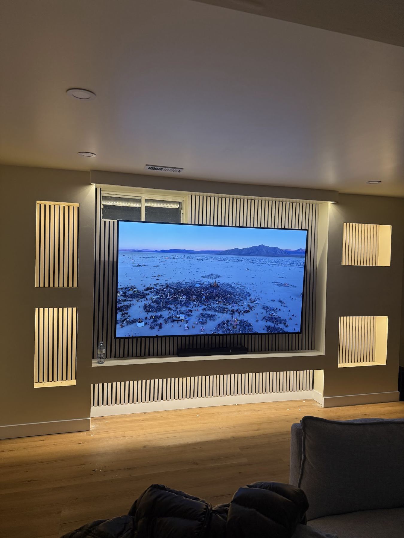 A media wall with warm LED slots around a television